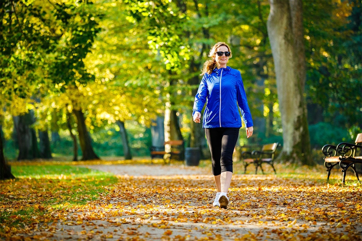 woman in athletic clothes walking on outdoor trail