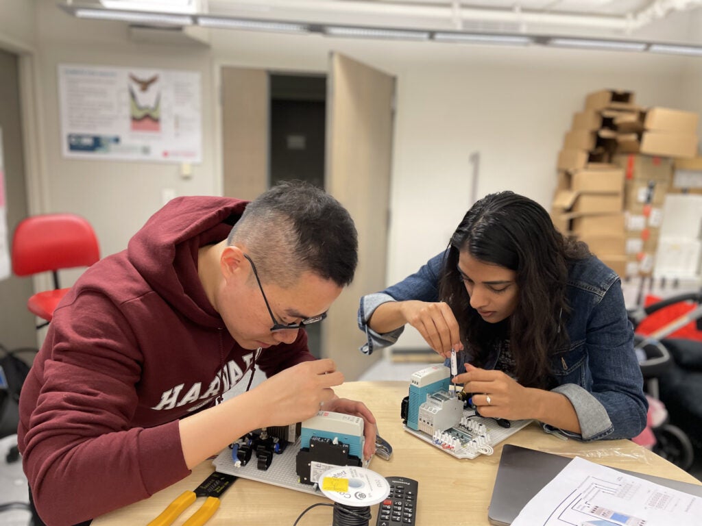 Two students from the Department of Environmental Health at Harvard Chan School working at a table