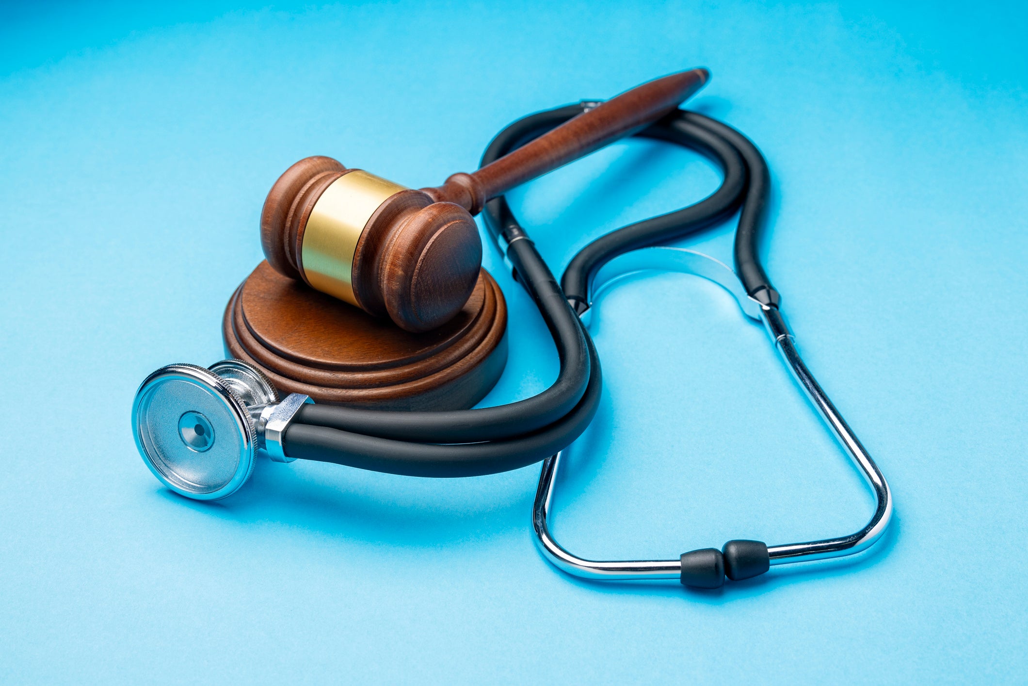 Gavel And Stethoscope on Blue Background